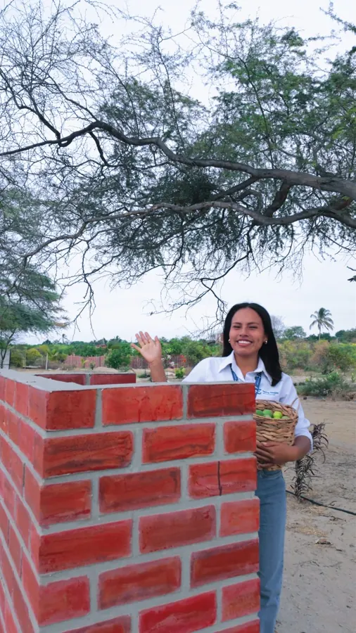 Asesora saludando junto a la parrilla del proyecto